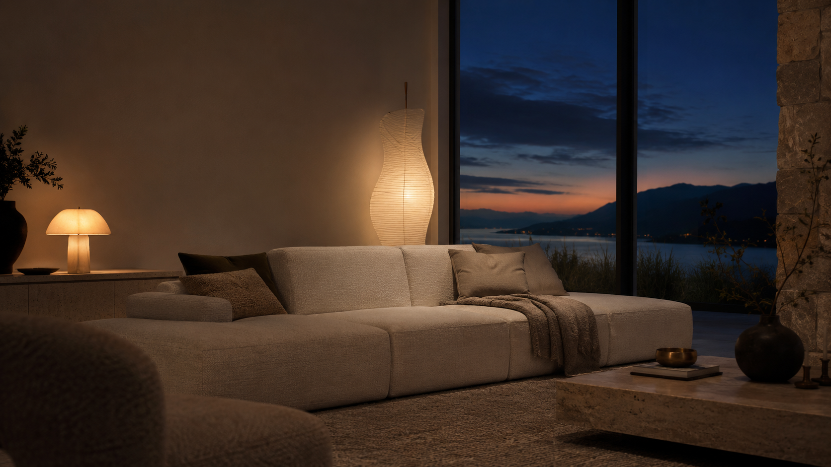 A warmly lit New Zealand living room at dusk with a modular sofa and twilight sky